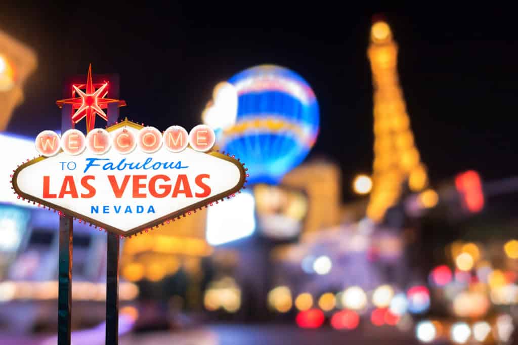 Famous Las Vegas sign with blur cityscape Famous Las Vegas sign at night with Las Vegas Cityscape blur background.